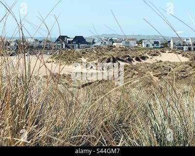 View through sand dunes to Rhosneigr Village, Anglesey, North Wales, Broad beach, traeth Llydan. Stock Photo