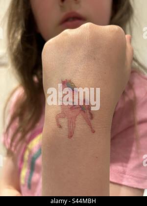 Temporary tattoo of a unicorn on a girls wrist Stock Photo