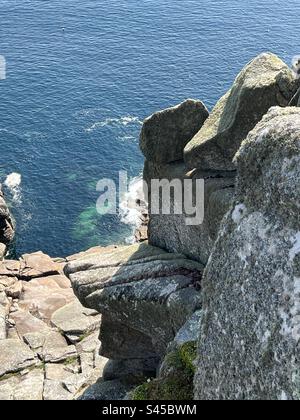 Rocky cliff and blue ocean below off the Cornish coast in summer Stock Photo