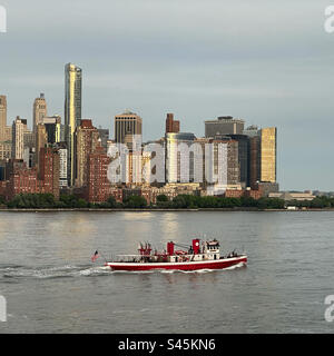 May, 2023, Fireboat on the Hudson River, Lower Manhattan in the background, New York, New York, United States Stock Photo