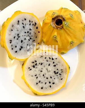 Cut yellow dragon fruit – Pitahaya – on a plate. Stock Photo