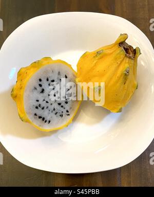 Cut yellow dragon fruit – Pitahaya – on a plate. Stock Photo