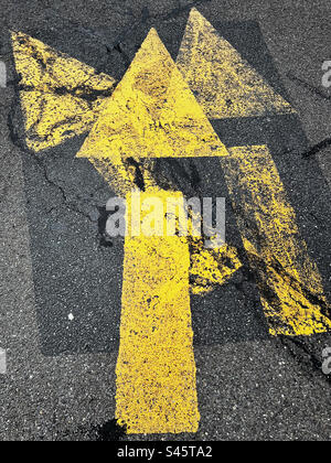 Layers of yellow painted arrows on the asphalt of a parking lot in New Jersey, USA. Stock Photo