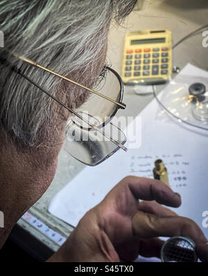 An older man uses two pairs of glasses for an engineering project in the workplace Stock Photo