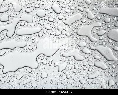 Pattern formed by droplets of water standing on a shiny metal surface. Backgrounds. Stock Photo