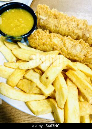 Chip shop style chips with two battered sausages and a portion of curry sauce Stock Photo