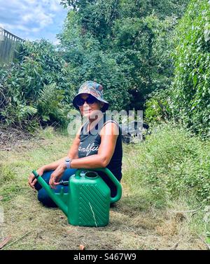 A young woman takes a rest from gardening. Stock Photo