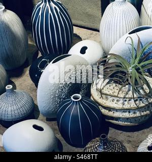 A variety of vases in blue and white with one green plant Stock Photo