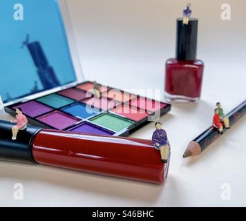 Miniature people sitting on assorted cosmetics Stock Photo