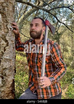 A woodcutter with axe in a forest Stock Photo