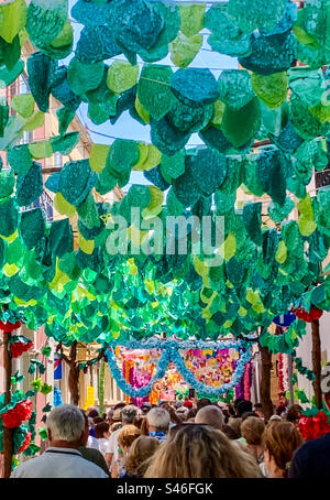 A crowd walk down the decorated streets in Tomar for Festas dos Tabuleiros Stock Photo