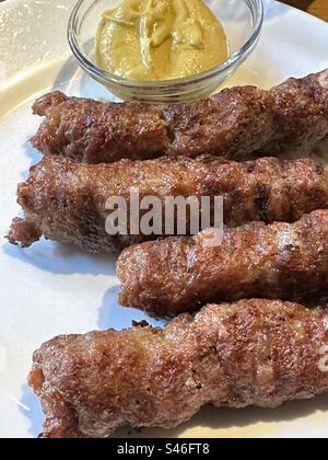 Mici, homemade sausages, traditional Romanian street food with senape sauce Stock Photo