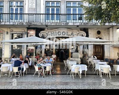 Café Nicola and esplanade with tourists eating and drinking, located in Lisbon downtown, Praça D.Pedro. Pombaline area. Stock Photo
