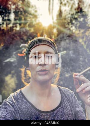 Woman smoking a big joint at sunset Stock Photo
