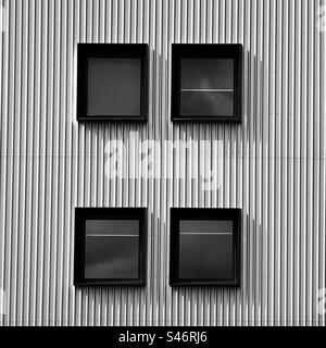 Abstract of square windows set in corrugated metal wall on modern building Stock Photo
