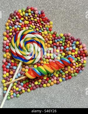 Lollipops on a heart shaped bed of sweets Stock Photo