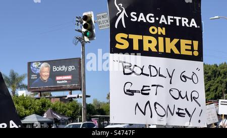 LOS ANGELES, CA, JUN 30, 2023: detail of Screen Actors Guild strike sign saying "Boldly go get our money" held by an actor in Hollywood. William Shatner poster on billboard in background Stock Photo