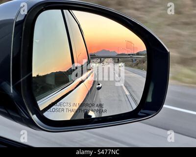 Sunset in the rear view mirror Stock Photo