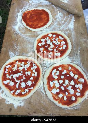 Pizza. Preparation of pizza. Pizza Margherita. Italian cooking. Pizza ready to bake. Pizze pronte per essere infornate. Stock Photo