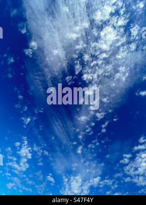 Cool clouds, thin wispy white ones and small spotty Tufty ones on blue sky Stock Photo
