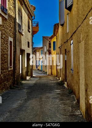 Walking down the street in Greoux les Bains Provence rustic road walk rocks cobblestone path quiet street house houses home road pavement sidewalk empty deserted south of France Stock Photo