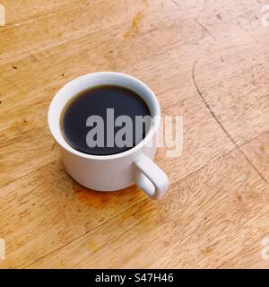A cup of black coffee on a brown table Stock Photo