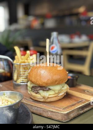 Delicious beef burger with french fries and drink on wooden table Stock Photo