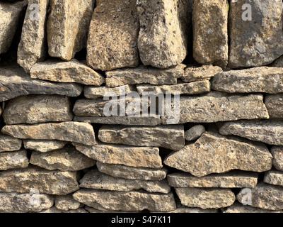 A section of beautifully crafted Cotswold Drystone wall lit by the Sun. Stock Photo