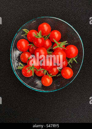 Cherry tomatoes in a glass dish with a black background Stock Photo