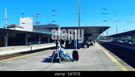 Man sitting on a bench at Porto train station in Portugal Stock Photo