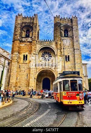 Number 28 tram passing the cathedral in Lisbon Portugal Stock Photo