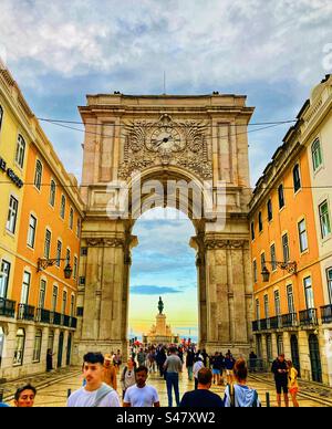 Walking through Arco da Rua Augusta archway in Lisbon Portugal at sunset looking towards Praça do Comércio Stock Photo