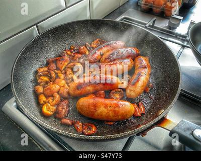 Sausages and mushrooms frying Stock Photo