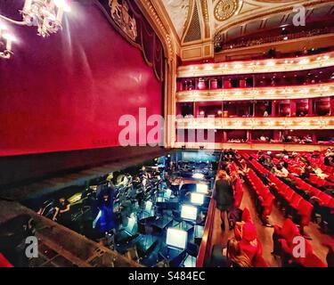 A night at the Opera - in the interval where the safety curtain is down we see the orchestra pit and stage in the Royal Opera House in Covent Garden, London. Stock Photo