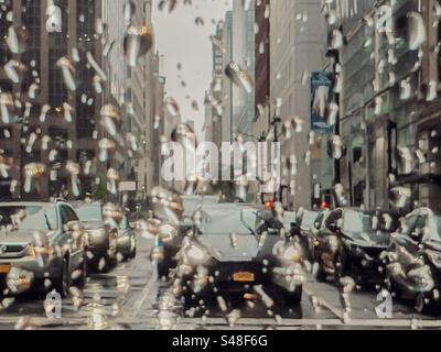 Traffic stopped at lights in New York City seen through a rain spattered window Stock Photo
