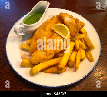 Fish and chips with a jug of mushy peas for linch at a pub. Stock Photo