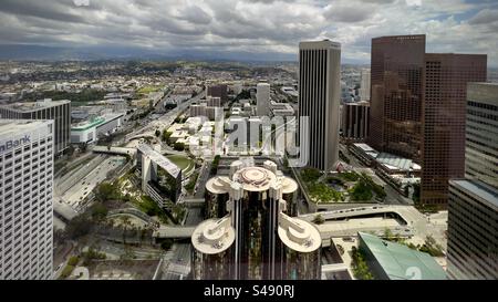 LOS ANGELES, CA, MAY 2023: High view looking over the Westin Bonaventure Hotel, towards various skyscrapers in Downtown. Mountains visible in distance Stock Photo
