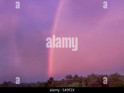 Window view of rainbow in dramatic sunset sky after the storm. Scenics-nature. Stock Photo