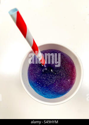 Top down view of a slushie with a red and white striped drinking straw. Stock Photo
