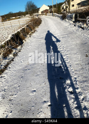 Shadow of mountain bike rider on snow Stock Photo