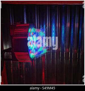 Cobweb illuminated by a disco light Stock Photo