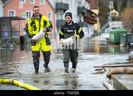 Passau, Germany. 16th Mar, 2019. Firefighters carry sandbags and walk on a road that is under water. The flood of the Ilz has flooded streets and plots of land in parts of Passau and has filled up cellars. Credit: Tobias Köhler/dpa/Alamy Live News Stock Photo