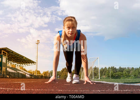 Athletic teenage girl in start position on track . Stock Photo by  ©DenysKuvaiev 11218985