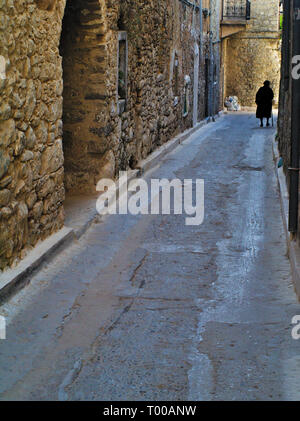 Old woman figure in medieval village of Mesta in Chios island, Greece. Traditional stone fortified village. Stock Photo