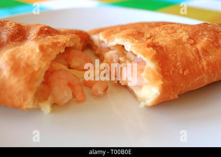 Empanadas de Camarones or Chilean Stuffed Pastry Filled with Shrimps and Cheese Cut in Half on White Plate