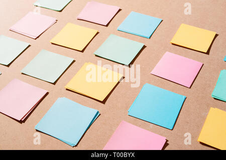 Multi colored notepads laying on a wooden plank board surface with copy space Stock Photo