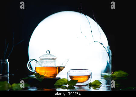 Tea in a double wall bowl and teapot against the full Moon. Chinese tea ceremony concept with copy space Stock Photo