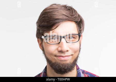 People and emotions concept - close up portrait of bearded young man in glasses on white background Stock Photo