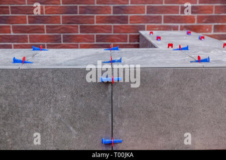 Laying ceramic tiles with leveling system. New tile alignment tools Stock Photo