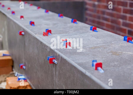 Laying ceramic tiles with leveling system. New tile alignment tools Stock Photo